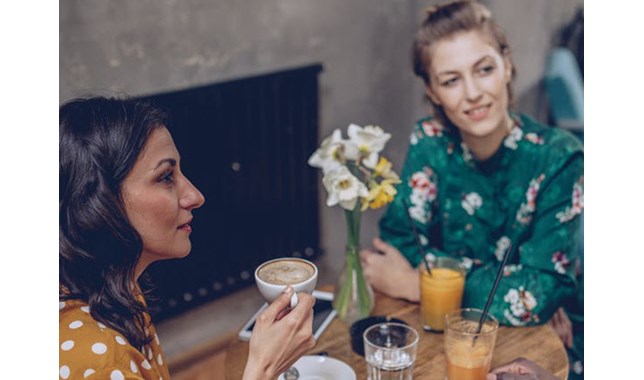 Woman talking with friends and drinking coffe
